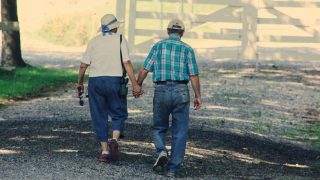 old couple walking while holding hands